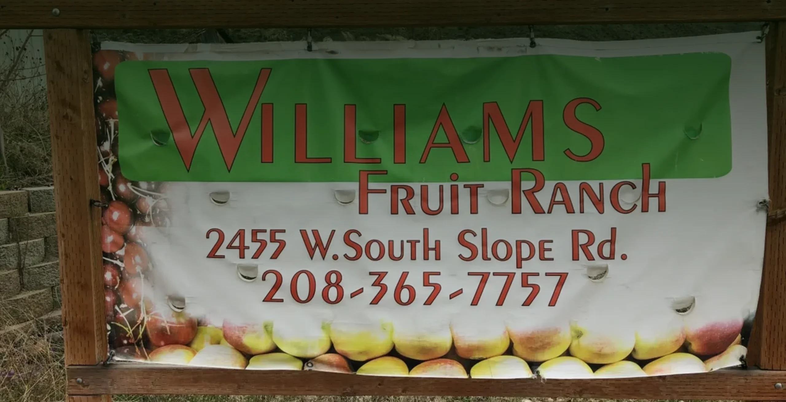 Orchard sign displaying location and phone number